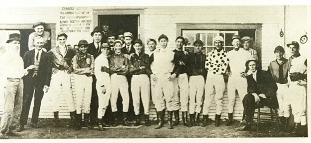 Black and white group photograph of jockeys and stable staff at the original Woodbine Race Track in 1914