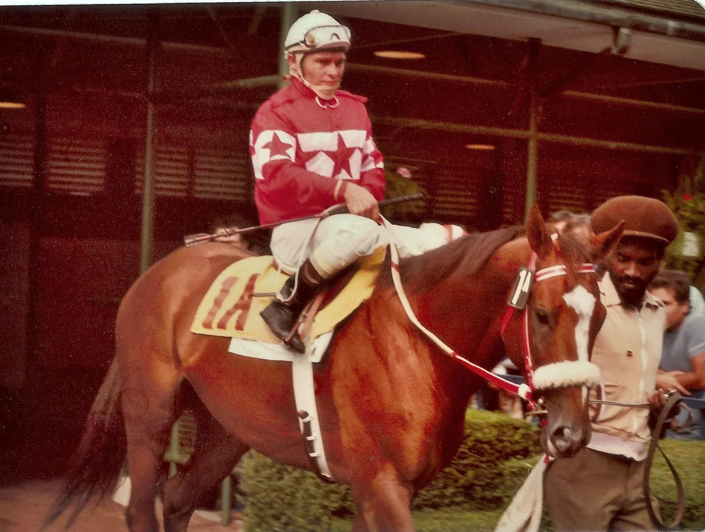 Archival colour photograph of a jockey on horseback being led through the paddock at Woodbine Racetrack in 1980
