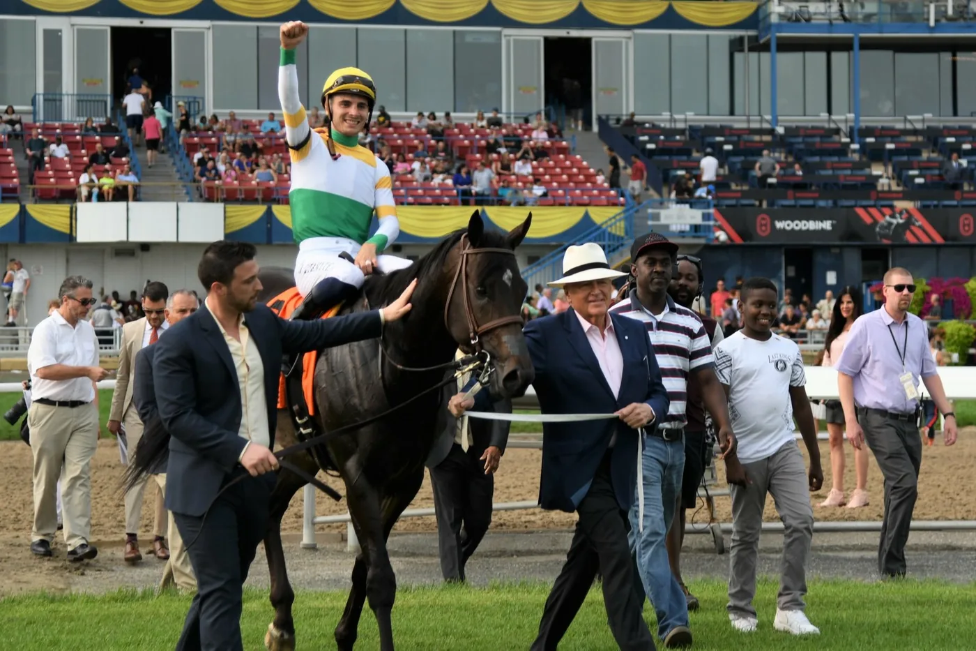Jockey and horse in the winner's circle at Woodbine Racetrack with grandstand seating behind